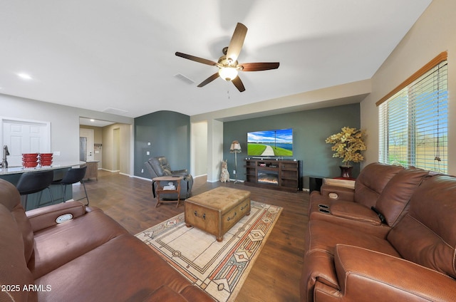 living room with dark wood-type flooring and ceiling fan