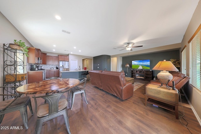 living room with dark wood-type flooring and ceiling fan