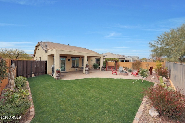 back of house featuring a yard, a patio, and an outdoor fire pit