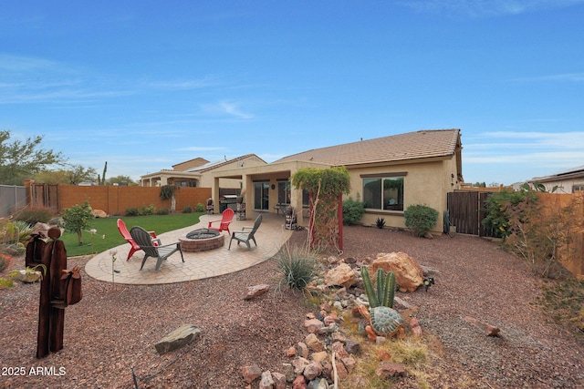 rear view of property with a patio area and an outdoor fire pit