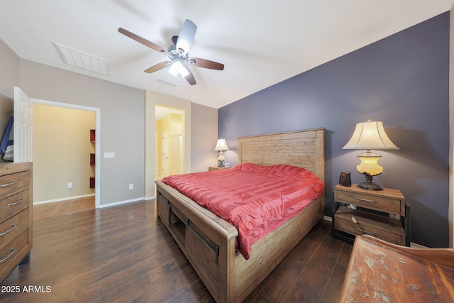 bedroom with ensuite bathroom, dark wood-type flooring, and ceiling fan