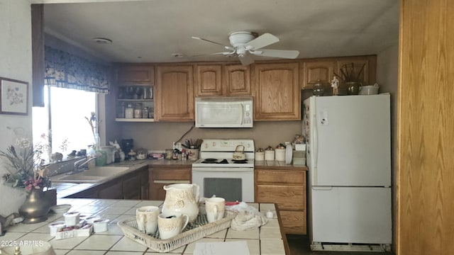 kitchen with white appliances, ceiling fan, tile counters, brown cabinets, and a sink