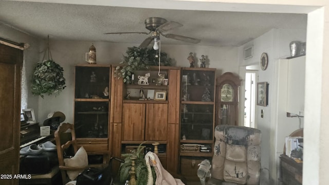 interior space featuring a ceiling fan, a textured ceiling, and visible vents