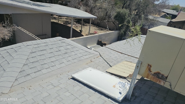 exterior details featuring roof with shingles