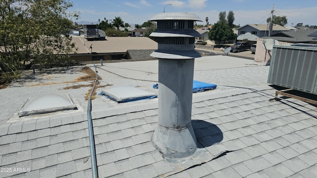 exterior details with cooling unit, a residential view, and roof with shingles