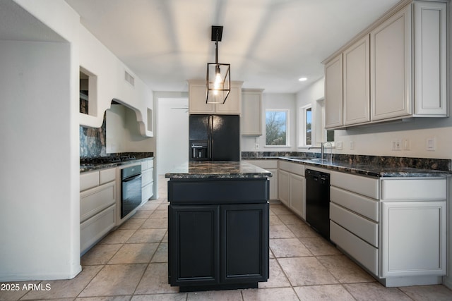 kitchen featuring decorative light fixtures, visible vents, a kitchen island, dark stone countertops, and black appliances