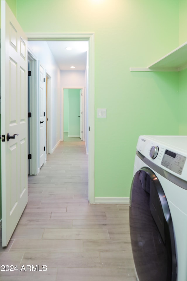 laundry room with light wood-type flooring and washer / clothes dryer