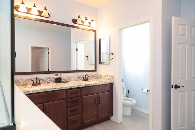 bathroom with hardwood / wood-style flooring, vanity, and toilet