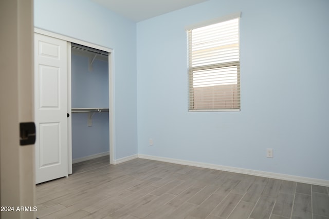 unfurnished bedroom featuring light hardwood / wood-style flooring and a closet