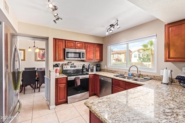 kitchen featuring light tile patterned flooring, pendant lighting, sink, light stone counters, and stainless steel appliances