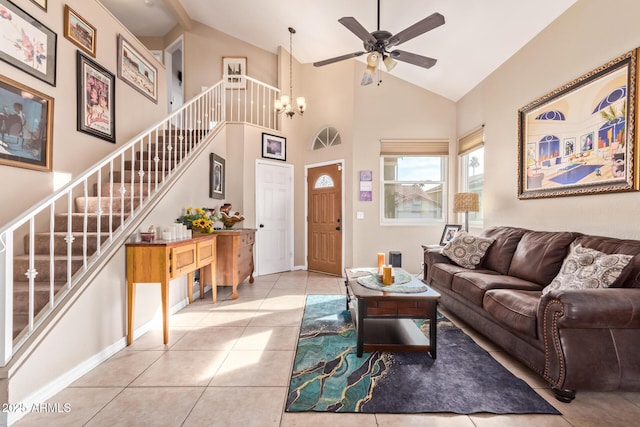 living room with ceiling fan with notable chandelier, light tile patterned floors, and high vaulted ceiling