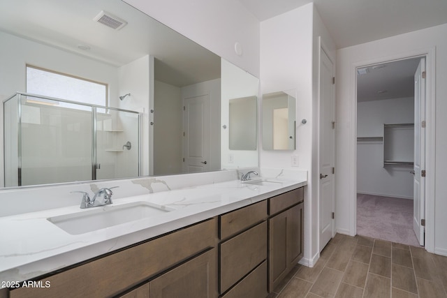 bathroom featuring an enclosed shower and vanity