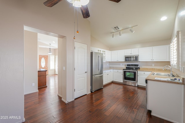 kitchen with sink, white cabinetry, vaulted ceiling, and stainless steel appliances