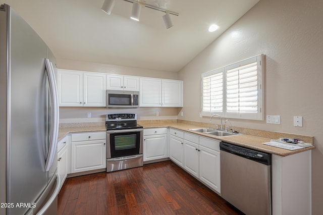 kitchen featuring white cabinets, appliances with stainless steel finishes, lofted ceiling, dark hardwood / wood-style flooring, and sink