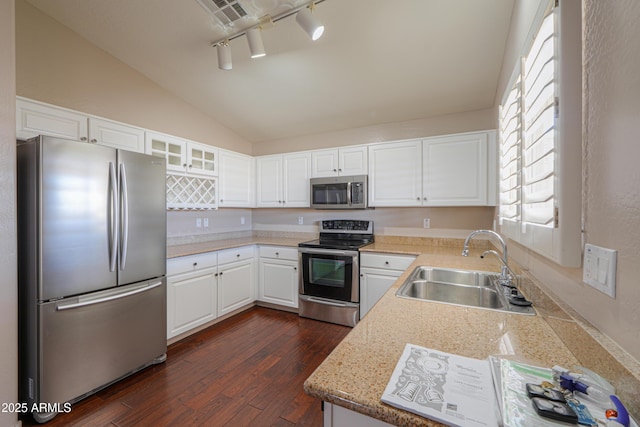 kitchen with white cabinets, appliances with stainless steel finishes, lofted ceiling, sink, and dark hardwood / wood-style floors