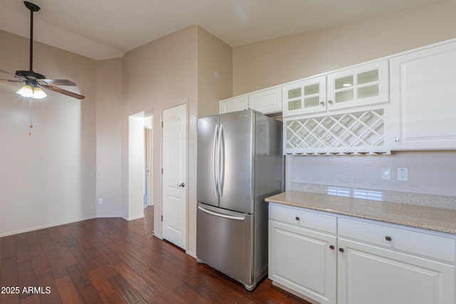 kitchen featuring white cabinets, ceiling fan, stainless steel refrigerator, and dark wood-type flooring