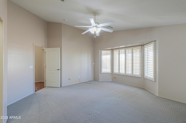 carpeted empty room with vaulted ceiling and ceiling fan