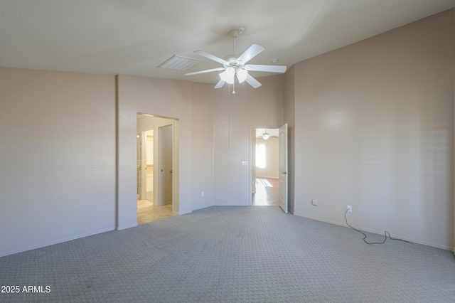 unfurnished bedroom with ceiling fan, light colored carpet, and ensuite bathroom