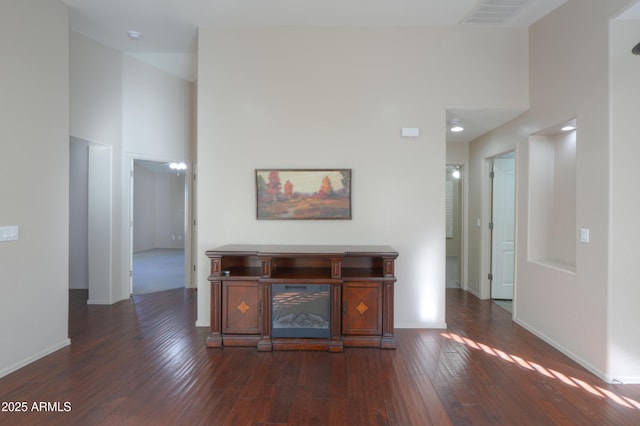 hallway featuring a high ceiling and dark hardwood / wood-style floors