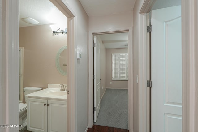 bathroom featuring vanity, toilet, hardwood / wood-style floors, and a textured ceiling