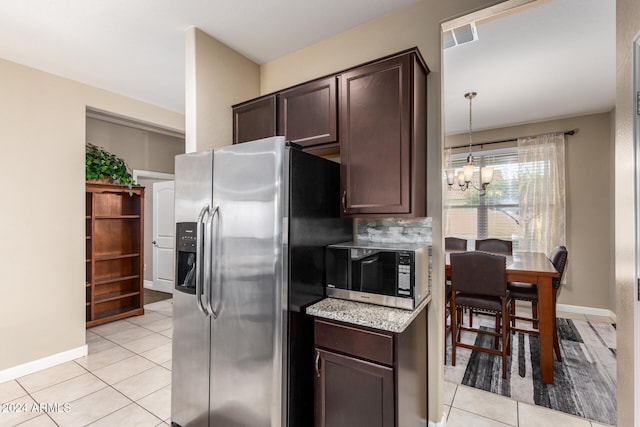 kitchen with light tile patterned flooring, dark brown cabinetry, appliances with stainless steel finishes, and an inviting chandelier