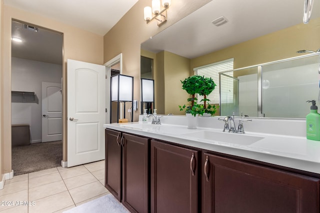 bathroom featuring tile patterned floors, a shower with door, and vanity