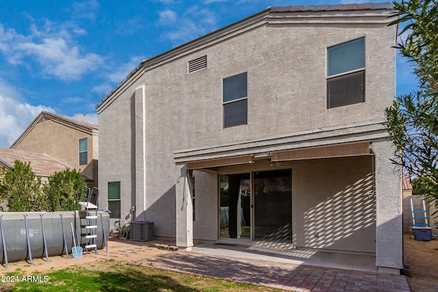 rear view of property with a patio and central AC