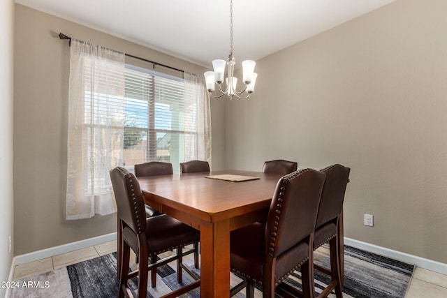 tiled dining room featuring an inviting chandelier