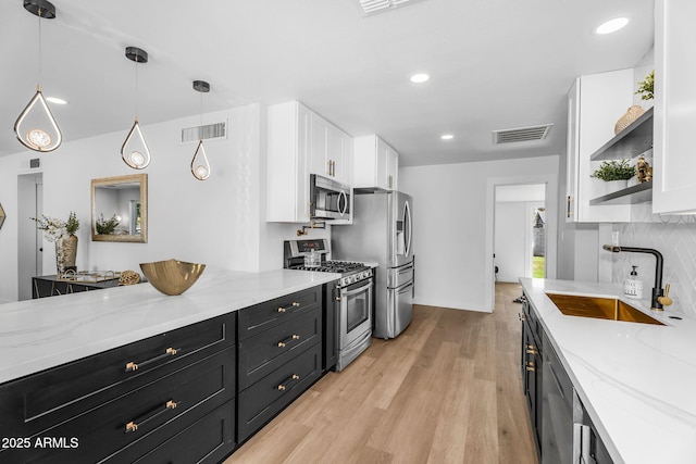 14635 N 37th Pl, Phoenix, AZ 85032 - kitchen featuring appliances with stainless steel finishes, a sink, dark cabinetry, white cabinetry, and light wood-type flooring