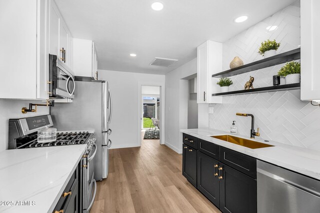 14635 N 37th Pl, Phoenix, AZ 85032 - kitchen featuring appliances with stainless steel finishes, a sink, white cabinets, dark cabinets, and light wood-style floors