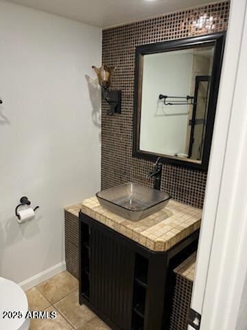 bathroom featuring tile patterned flooring, vanity, and toilet