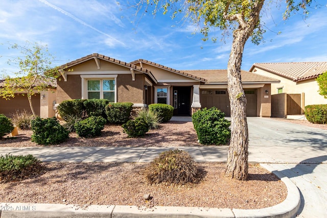 view of front of home featuring a garage, concrete driveway, fence, and stucco siding