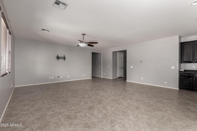 unfurnished living room with baseboards, visible vents, and a ceiling fan