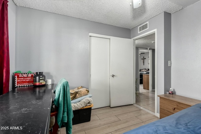 8623 W Indianola Ave, Phoenix, AZ 85037 - bedroom with a closet, wood finish floors, a textured ceiling, and visible vents