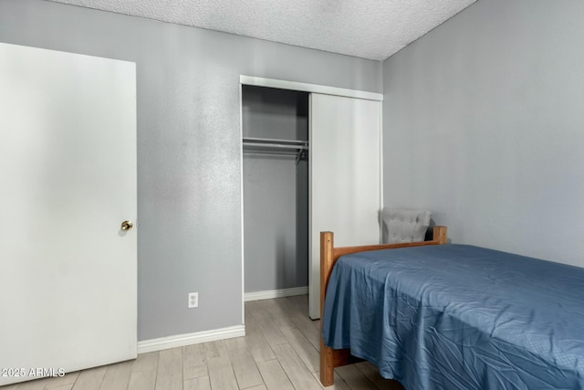 8623 W Indianola Ave, Phoenix, AZ 85037 - bedroom featuring baseboards, a textured ceiling, wood finished floors, and a closet