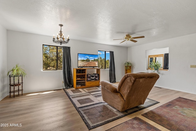 5766 N Juliane Dr, Williams, AZ 86046 - living room featuring a chandelier, light wood finished floors, a ceiling fan, baseboards, and a textured ceiling
