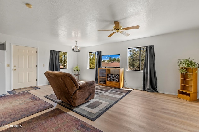 5766 N Juliane Dr, Williams, AZ 86046 - living room featuring light wood finished floors, a ceiling fan, a chandelier, and baseboards