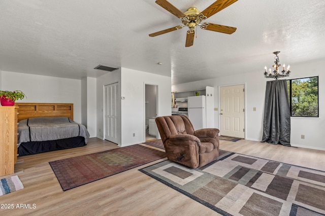 5766 N Juliane Dr, Williams, AZ 86046 - bedroom with light wood-style floors, a chandelier, freestanding refrigerator, baseboards, and a textured ceiling