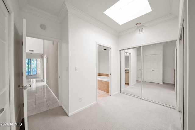 interior space featuring light carpet, a skylight, and crown molding