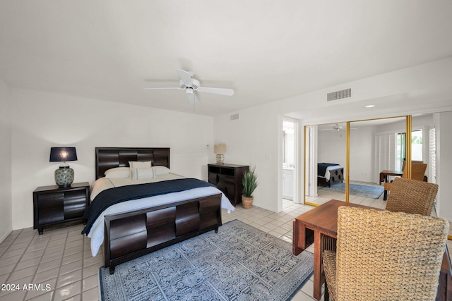 tiled bedroom featuring ceiling fan and a closet