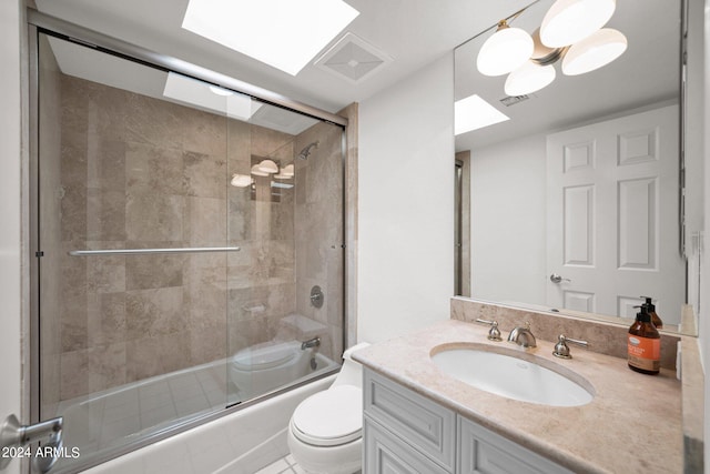 full bathroom featuring enclosed tub / shower combo, vanity, toilet, and a skylight