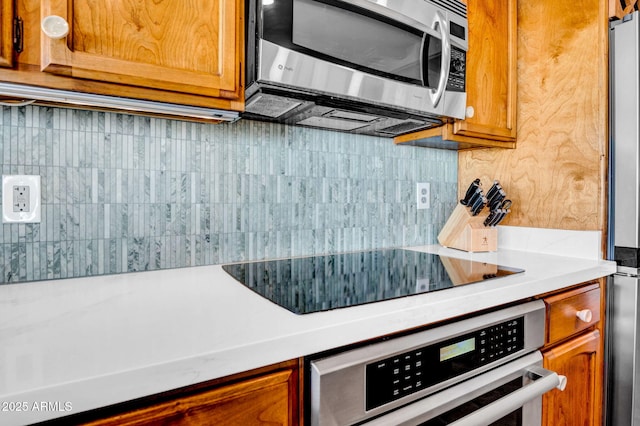 kitchen with tasteful backsplash and appliances with stainless steel finishes