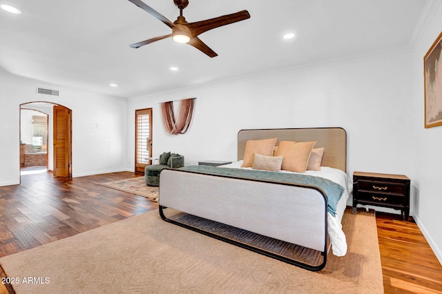 bedroom featuring hardwood / wood-style flooring, ornamental molding, and ceiling fan