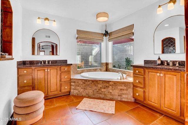 bathroom featuring vanity and tiled bath