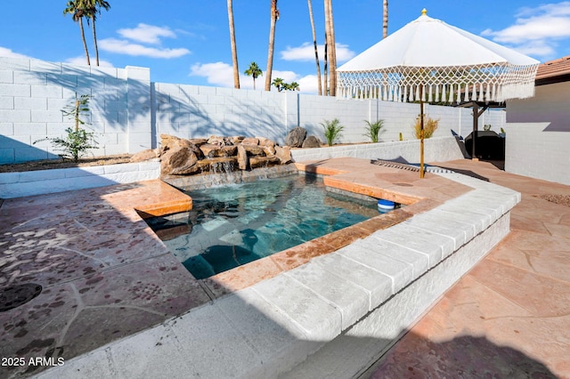 view of swimming pool featuring pool water feature and grilling area