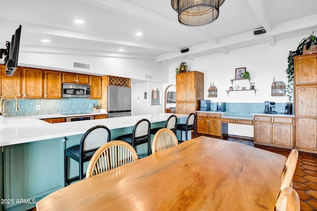 dining area with sink and vaulted ceiling with beams