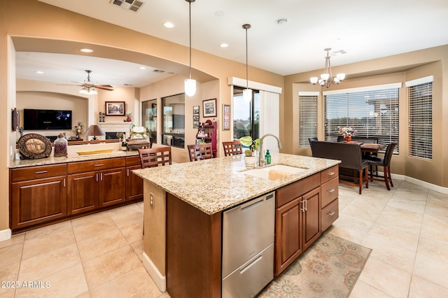 kitchen with dishwasher, an island with sink, open floor plan, pendant lighting, and a sink