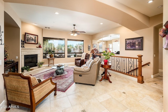 living room featuring ceiling fan and a premium fireplace