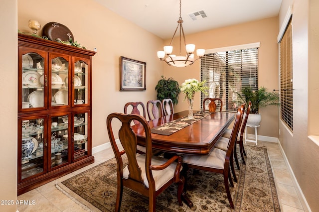 dining room featuring light tile patterned flooring and a notable chandelier