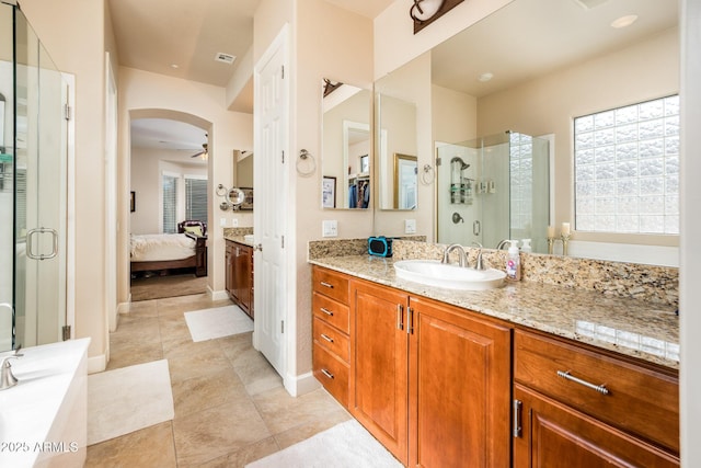 bathroom with walk in shower, ceiling fan, vanity, and tile patterned floors